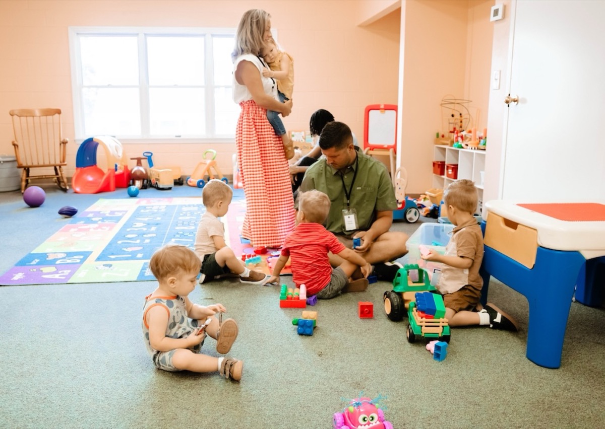 A CTK Kids teacher holding a child in the classroom
